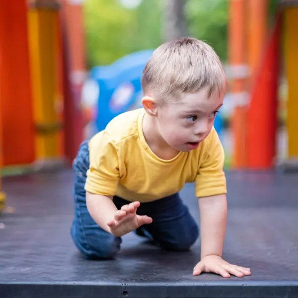 Neugieriges Vorschulkind mit Down-Syndrom auf Spielplatz