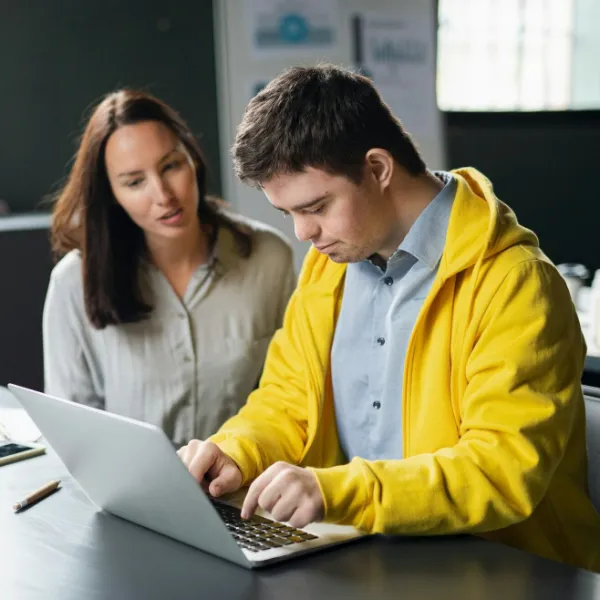 Ein junger Mann mit Down-Syndrom besucht einen Computerkurs